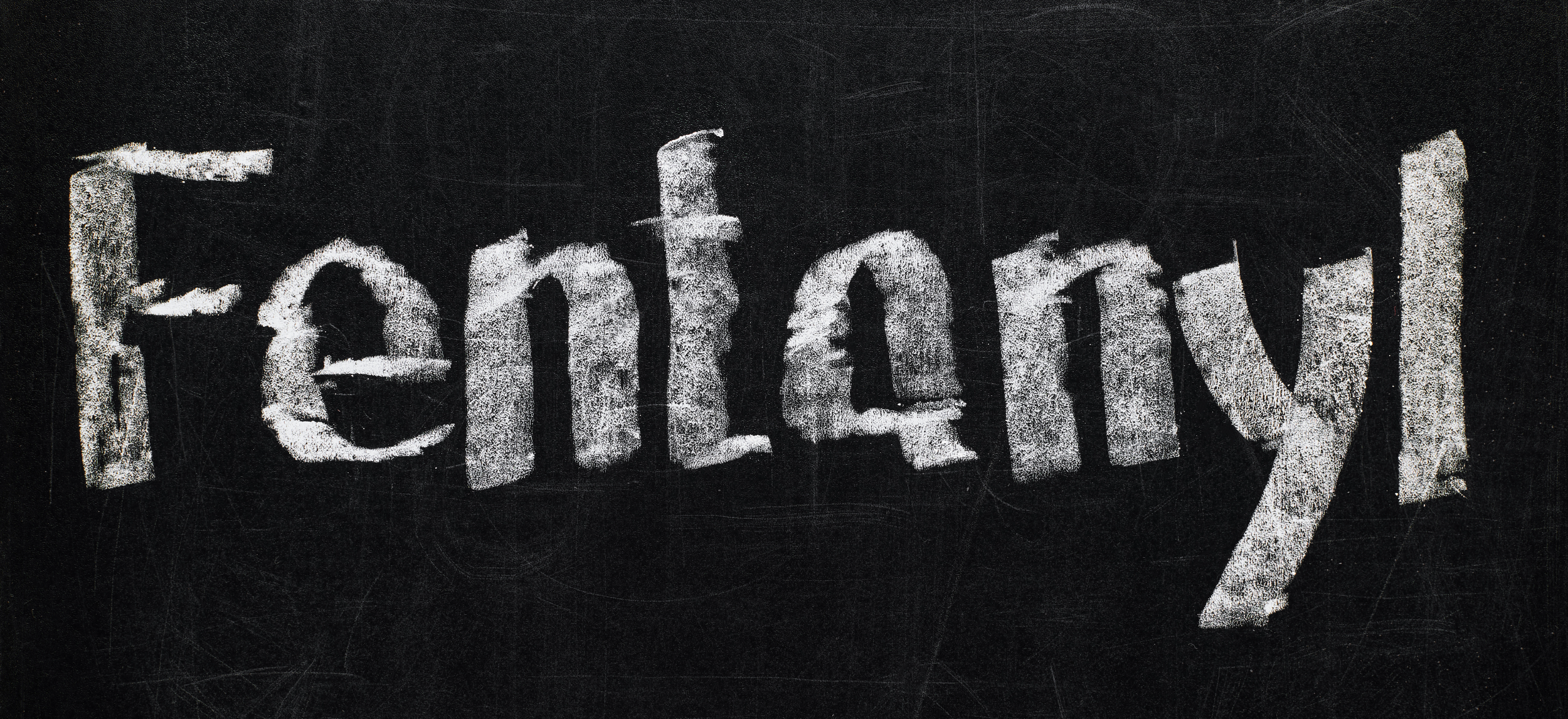 The word Fentanyl spelled in white chalk on a black background